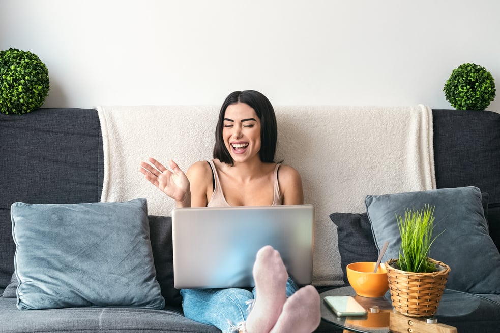 Woman Happily Video Calling in Laptop while Sitting on Sofa